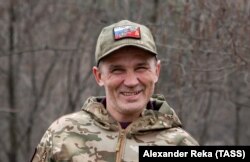 რუს მოხალისე მებრძოლს უკრაინის ლუგანსკის რეგიონში, კრემენაიას მახლობლად, ახურავს ქუდი, რომელზეც რუსული და საბჭოთა სიმბოლოებია შერწყმული. 2023 მაისი.