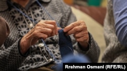 Një grua në Shtëpinë e Personave të Moshuar dhe pa Përkujdesje Familjare në Prishtinë duke qendisur. 