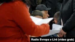 Pacientë duke mbajtur në duar raporte mjekësore teksa presin në ambulancat specialistike në QKUK. Dhjetor 2023. 