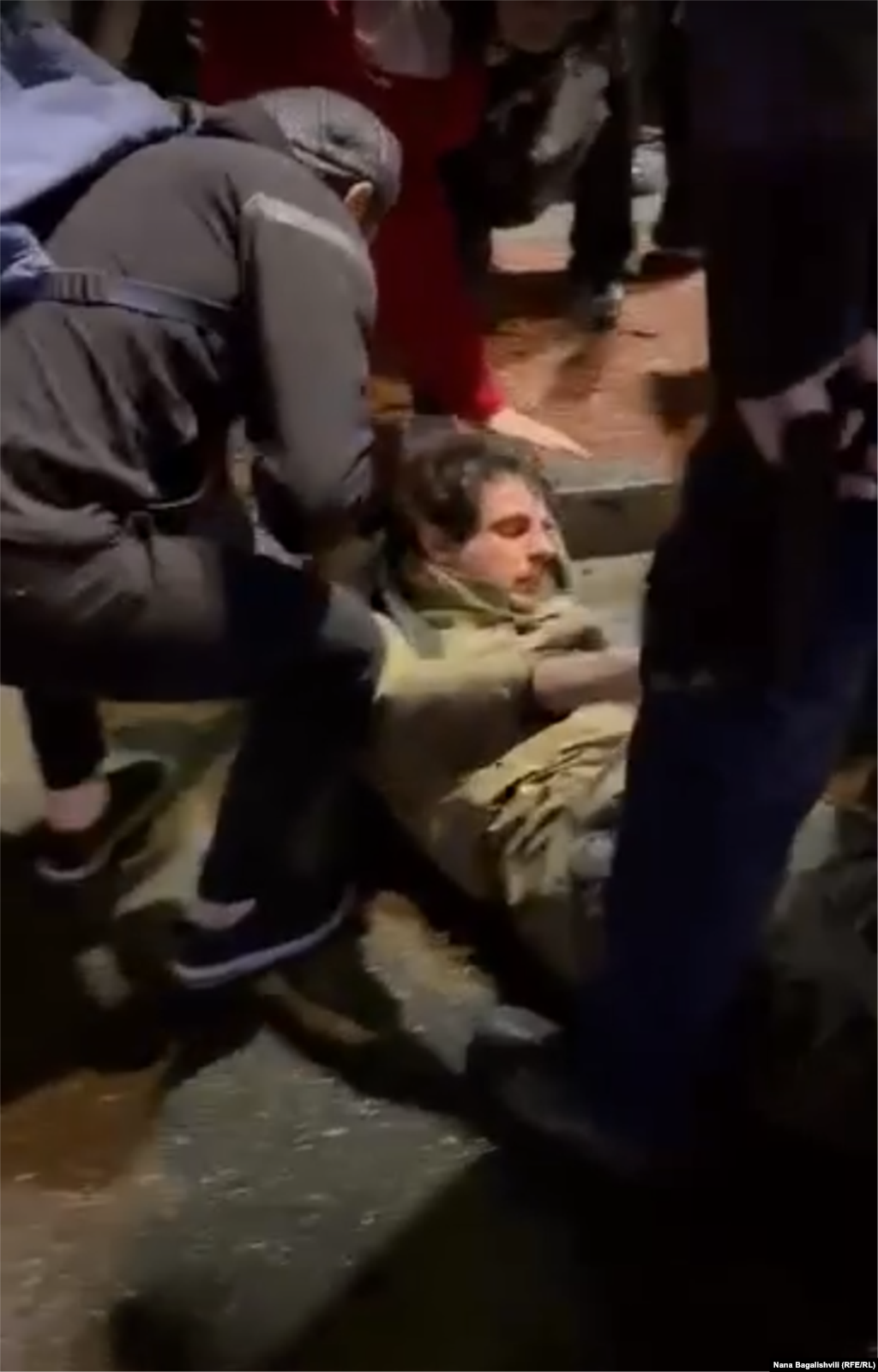 An injured man is helped by protesters at Heroes' Square early on May 3. Eyewitnesses, including two injured men, told RFE/RL that what they called "provocateurs" arrived by car around 1 a.m. and physically assaulted some of the protesters. &nbsp;