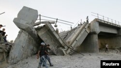 პალესტინელი პოლიციელები ღაზის სექტორში დანგრეულ ხიდთან. ხიდს ისრაელის რაკეტა მოხვდა. 2006 წლის 28 ივნისი.