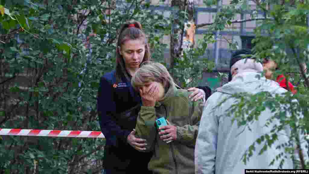 За даними Київської міської військової адміністрації, внаслідок падіння уламків російських ракет у Києві у ніч проти 1 червня&nbsp;загинули троє людей, з них одна дитина. Ще 11 зазнали поранень. На фото: жінка плаче над тілом своєї доньки, яка стала однією із жертв чергової атаки РФ на Київ, 1 червня 2023 року &nbsp;