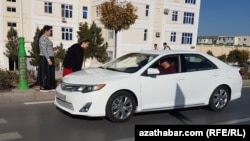 Hususy ulagynda kireý edýän sürüji bilen gürleşýän aşgabatly ýaşaýjylar (Illýustrasiýa suraty)