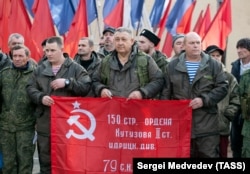 მობილიზებულ ჯარისკაცებს და მოხალისეებს საბჭოთა დროშა უჭირავთ უკრაინაში გამგზავრების წინ. რუსეთი, ორენბურგი, 2022 ოქტომბერი.