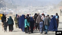 Afghan refugee families arrive on foot to cross the Pakistan-Afghanistan border at Torkham on November 2.