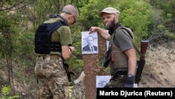 Бійці стрілецького батальйону «Карпатська Січ» готують мішені із зображенням президента Росії Володимира Путіна під час навчань для новобранців на стрільбищі в Харківській області, 30 червня 2022 року