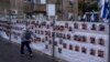  Israel - Un bărbat trece pe lângă un gard cu fotografii cu ostatici, în mare parte civili israelieni, care au fost răpiți în timpul atacului fără precedent al Hamas din 7 octombrie asupra Israelului, în Ramat Gan, Israel, miercuri, 22 noiembrie 2023.