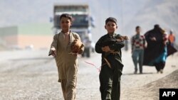 په تورخم کې دوه کډوال ماشومان له خپلو چرګانو سره افغانستان ته داخلېږي - د نومبر دویمې انځور.