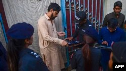 په کراچۍ کې پولیس د لټون عملیاتو پر مهال د یو افغان کډوال د ګوتې نښه ثبتوي - د نومبر ۱۷مې انځور.