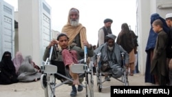 مردی در حال انتقال ویلچر پسر معلولش. 