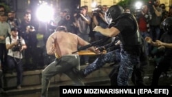 Riot police attack an opposition protester near the parliament building in Tbilisi on May 1. 