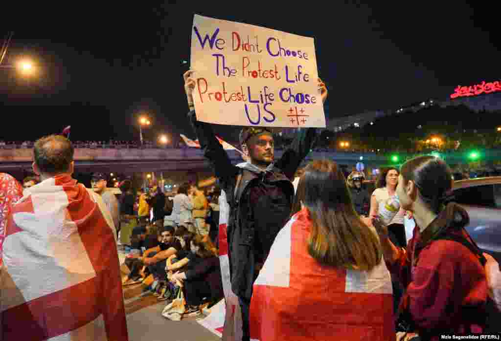 A protester opposed to the controversial "foreign agent" bill stands in the center of Heroes' Square in Tbilisi during a rally on May 2&ndash;3. The European Union and the United States have condemned the controversial legislation that is making its way through Georgia's parliament following violent clashes&nbsp;between police and protesters that broke out late on May 1.