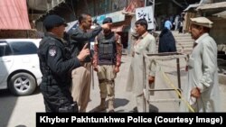 پولیس په منځنۍ کورمه کې د لټون عملیاتو پر مهال له خلکو پوښتنې کوي - پخوانی انځور. 