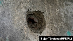 Një vrimë e shkaktuar në shtëpinë e familjes Gashi nga predha e artilerisë së forcave serbe gjatë luftës së vitit 1999, në fshatin Landovicë, Prizren.