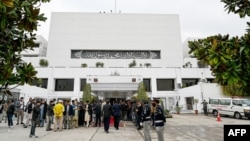 پولیس، د قامي اسمبلۍ ځینې استازي او خبریالان په اسلام اباد د پاکستان د پارلېمان ودانۍ مخې ته ولاړ دي - د مارچ درېیمې انځور.