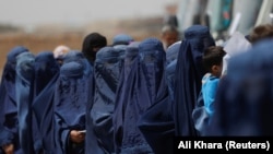 آرشیف، شماری از زنان نیازمند افغان که برای دریافت کمک صف کشیده اند.