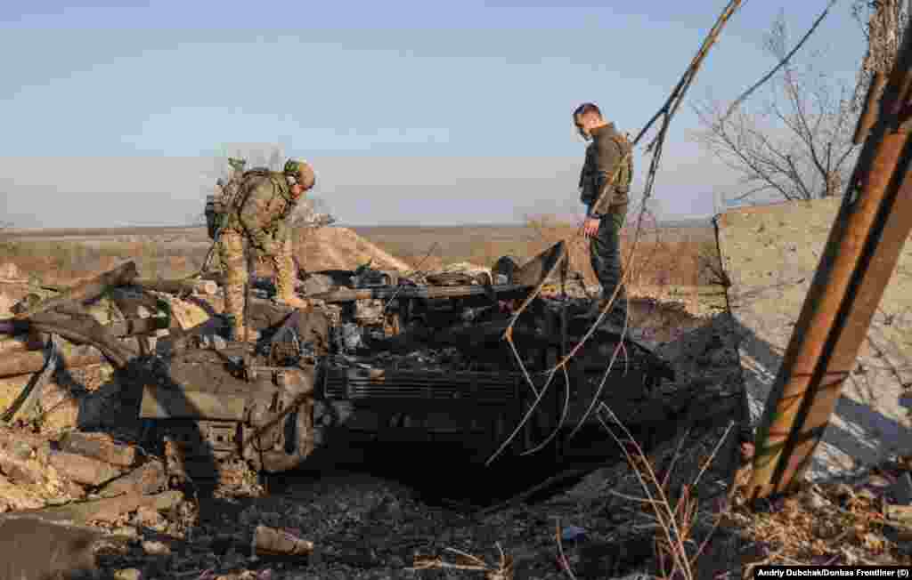 Ukrainian troops examine a destroyed tank. Dubchak says he asked locals whether possible war crimes took place in Snihurivka during its occupation by Russian forces but says, "For now, there is no information."&nbsp; &nbsp;