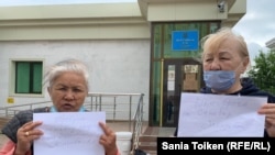 Пенсионерки Алтын Жандосова (слева) и Зейнегуль Кутпанбетова у здания Верховного суда проводят акцию в поддержку гражданской активстки Санавар Закировой. Нур-Султан, 29 июня 2020 года. 