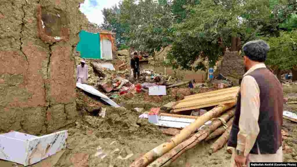 یک باشنده خوشی لوگر به خانۀ تخریب شده اش نگاه می کند. باشندگان این ولسوالی از حکومت طالبان و جامعه جهانی خواستار رسانیدن کمک های عاجل هستند