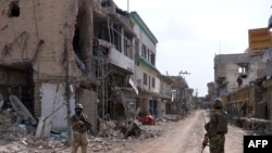 پاکستاني پوځيان د ميرامشا په وران کړي بازار کې ولاړ دي. پخوانی انځور.