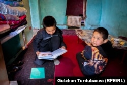 Абдимажит иниси Абдикарим менен китеп окуп жатышат.