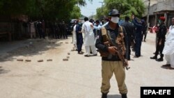 Pakistani security officials stand guard at a the scene of a blast in Ghotki, Sindh Province on June 19.
