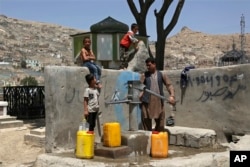 Суу толтуруп жаткан оогандык үй-бүлө