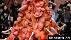 „Stâlpul rușinii”, statuia de la Universitatea Hong Kong dedicată evenimentelor din 1989 din piața Tiananmen, a fost înlăturată în 2021 pe motivul că ar fi devenit un pericol pentru siguranța publică. (Foto: studenți curăță memorialul dedicat victimelor masacrului. 4 iunie 2019)