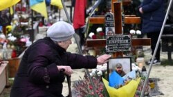 O femeie plânge la mormântul unui soldat ucrainean din cimitirul Lîceakiv, Lviv, 6 decembrie 2022.