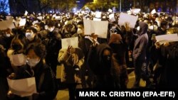 Protestatari și polițiști chinezi stau față în față în timpul unei demonstrații împotriva restricțiilor Covid, în Shanghai, China. 27 noiembrie 2022.