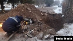 Жарылган жылуулук куурун оңдоп жаткан жумушчу. Орловка шаары. Декабрь, 2022-жыл.