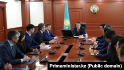 Премьер-министр Казахстана Алихан Смаилов (в центре) представляет нового министра культуры и спорта Асхата Оралова, бывшего функционера партии власти (сидит первым за столом слева). Астана, 4 января 2023 года                              
