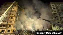 Рятувальники розчищають завали після влучання російської ракети в багатоповерховий будинок. Дніпро, 14 січня 2023 року