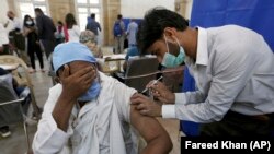 COVID-19га каршы вакцина алып жаткан киши. Пакистан. 2021-жылдын 10-марты. 
