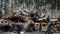 Locuitori din Irpin, în fața mașinilor distruse