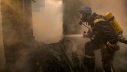 Un pompier ucrainean pulverizează apă pe o casă distrusă miercuri de obuze în Kiev, 23 martie 2022. (AP Foto/Vadim Ghirda)
