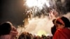 People watch fireworks light the sky as they attend a ceremony celebrating Norouz, the Persian New Year, at the Iran Mall shopping center in Tehran on March 20.