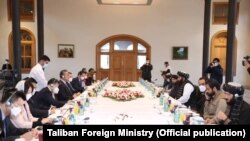 د چين د بهرنيو چارو وزير وانګ يي او نور چينايي چارواکي د ۲۰۲۲ز کال د مارچ پر ۲۴مه د طالبانو د بهرنيو چارو له سرپرست وزير امير خان او ځينو نورو طالب چارواکو سره خبرې کوي