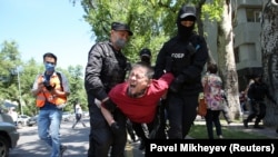 Полицейские несут задержанного в автозак. Алматы, 6 июня 2020 года.
