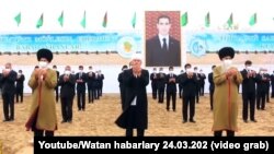 Туркменские старейшины и чиновники на фоне изображения президента Сердара Бердымухамедова, который занял пост в марте 2022 года вместо отца