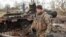 Украинский военнослужащий возле уничтоженного российского танка Т-72 в освобожденном селе Лукьяновка Киевской области, 27 марта 2022 года