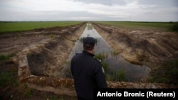 Un polițist frontieră patrulează granița dintre Croația și Serbia la Tovarnik, estul Croației, pe 12 mai 2013. Croația a devenit al 28-lea membru al Uniunii Europene pe 1 iulie al acelui an, iar granița sa terestră cu vecinii din afara UE e de aproximativ 1.400 km.