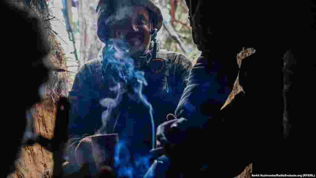 Українські військові палять та п'ють чай під час російського артилерійського обстрілу, 31 березня 2022 року