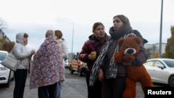 Femei discutând în stradă la Kiev, în fața unuia din blocurile lovite de noile atacuri rusești.