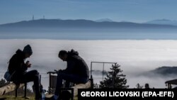 Луѓето уживаат во сончевиот ден на планината кај селото Кучково, над главниот град покриен со смог и загадување Скопје, Република Северна Македонија, 02 јануари 2023 година.