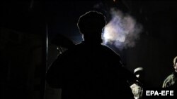 "Талибандын" өкүлү Тышкы иштер министрлигинин жанындагы кол салуудан кийин коопсуздукка көзөмөл салып турат. Сүрөт караңгыда тартылган. 11-январь, 2023-жыл.