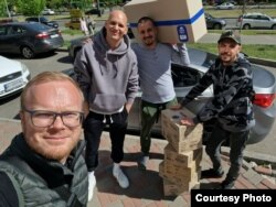 Roman (foreground) and friends collect packages in Kyiv for the elderly.