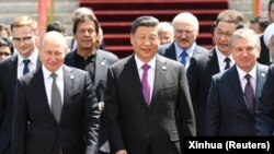 Шанхай ынтымақтастық ұйымы жиынына келген Қытай президенті Си Цзиньпин (ортада), Ресей президенті Владимир Путин (сол жақта), Өзбекстан президенті Шавкат Мирзияев (оң жақта) және басқа да мемлекет басшылары. Бішкек, Қырғызстан,  14 маусым 2019 жыл.