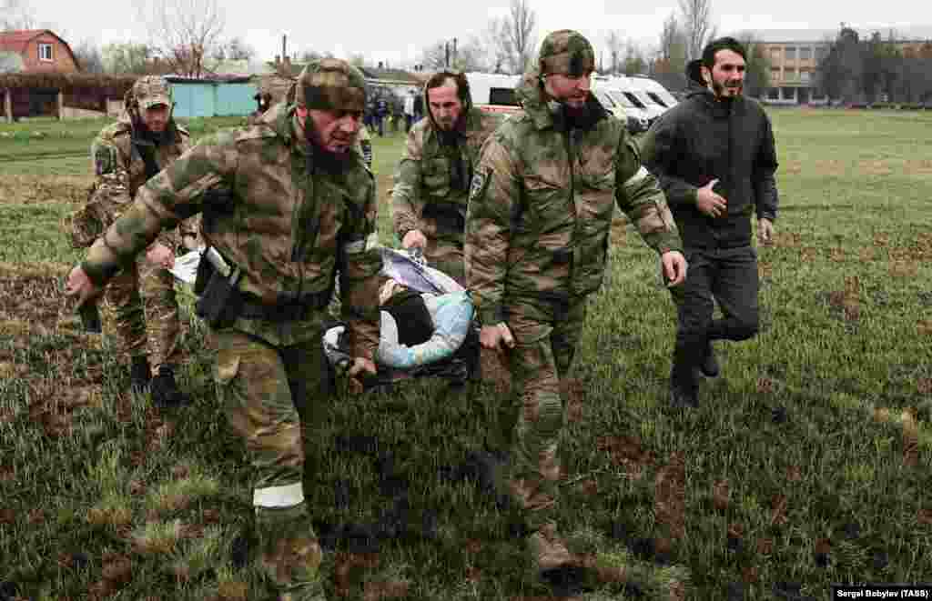 Troops from Russia's Chechnya region evacuate a wounded man from the battlefield in Novoazovsk on April 12.&nbsp;