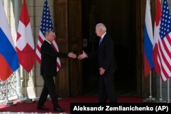 Vladimir Putin și Joe Biden dau mâna înainte să intre în clădirea în care are loc summit-ul.